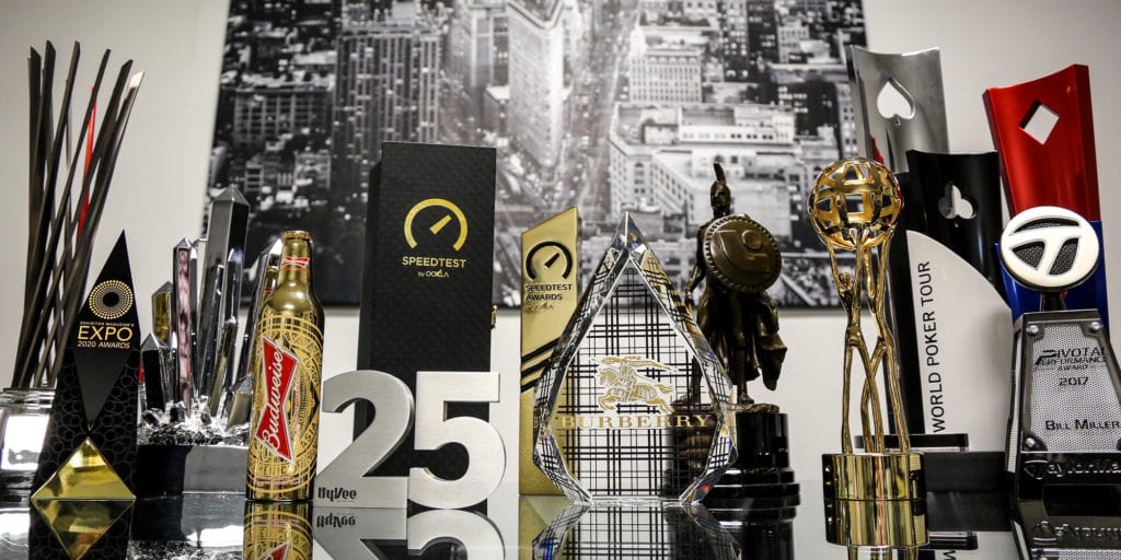 A group shot of crystal and metal custom awards by Cristaux