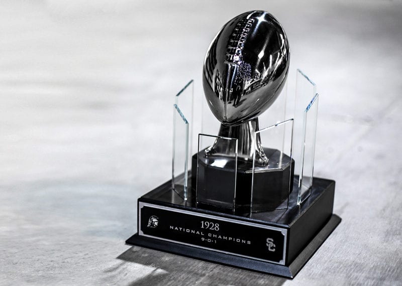 Metal football trophy for USC Trojans, surrounded by crystal panels on base