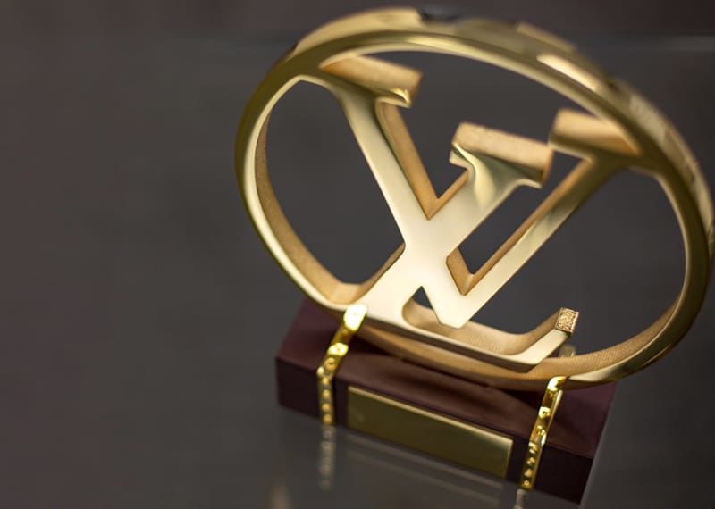 cut and polished Louis Vuitton logo on leather wrapped base