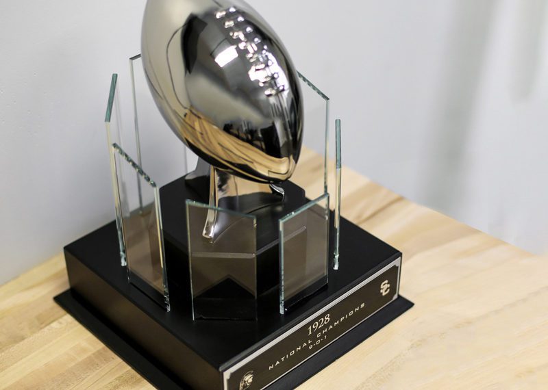 Wood base with crystal panels, and metal football. Sports college football trophy USC Trojans