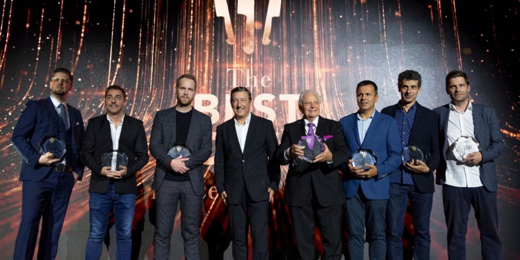 Award show ceremony recipients on stage with crystal awards