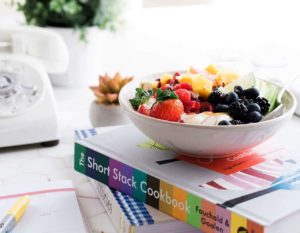 bowl with fresh fruit on a pile of books