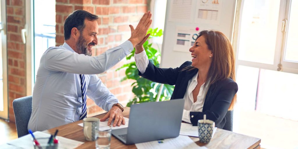 Happy Employees High Five in Work Setting